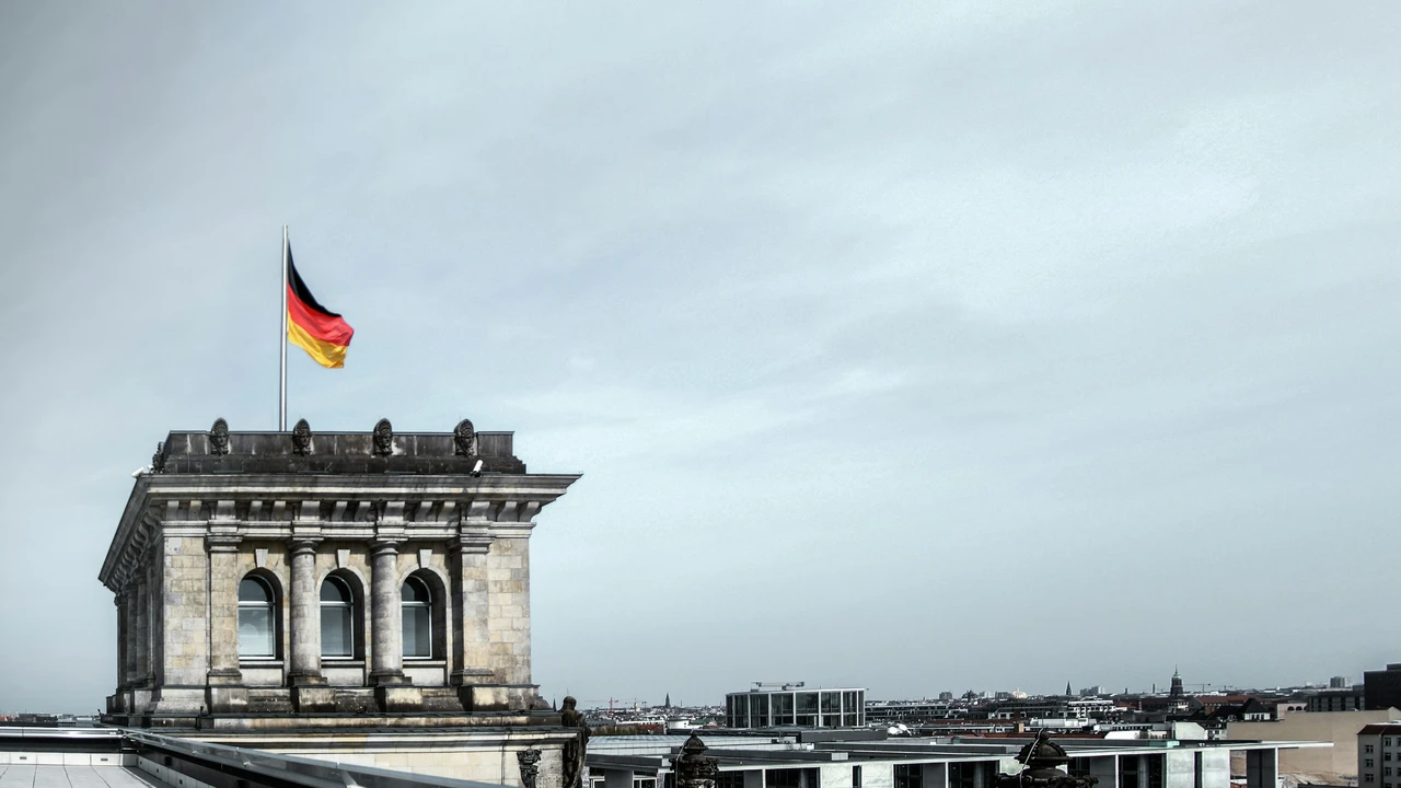 German flag flying over a historic government building in Berlin, symbolizing Germany visa requirements and the importance of approved travel insurance for Germany visa applications.