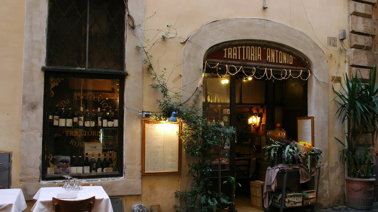 Dinner at a traditional Roman trattoria in Rome, Italy, featuring a cozy restaurant entrance, classic Italian decor, and authentic local dining atmosphere.