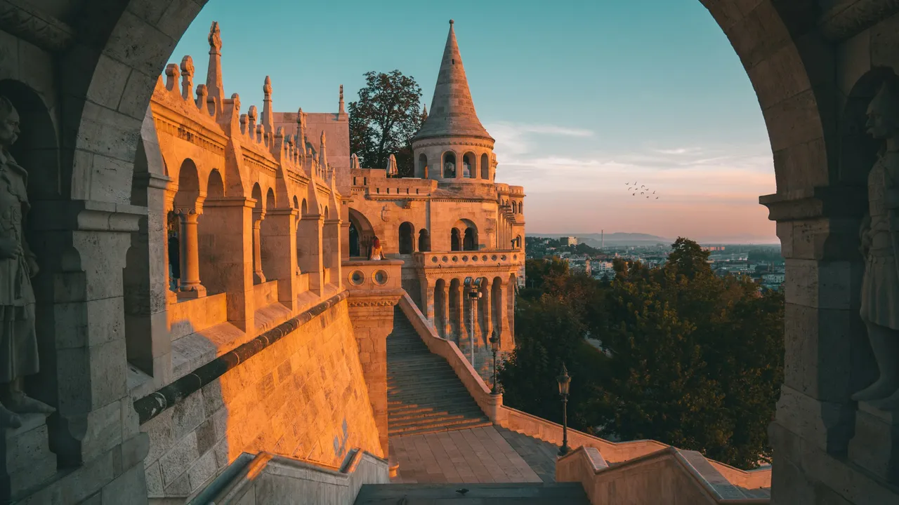 Explore Buda Castle and Fisherman’s Bastion at sunset in Budapest, featuring historic stone arches, panoramic city views, and iconic Hungarian architecture.