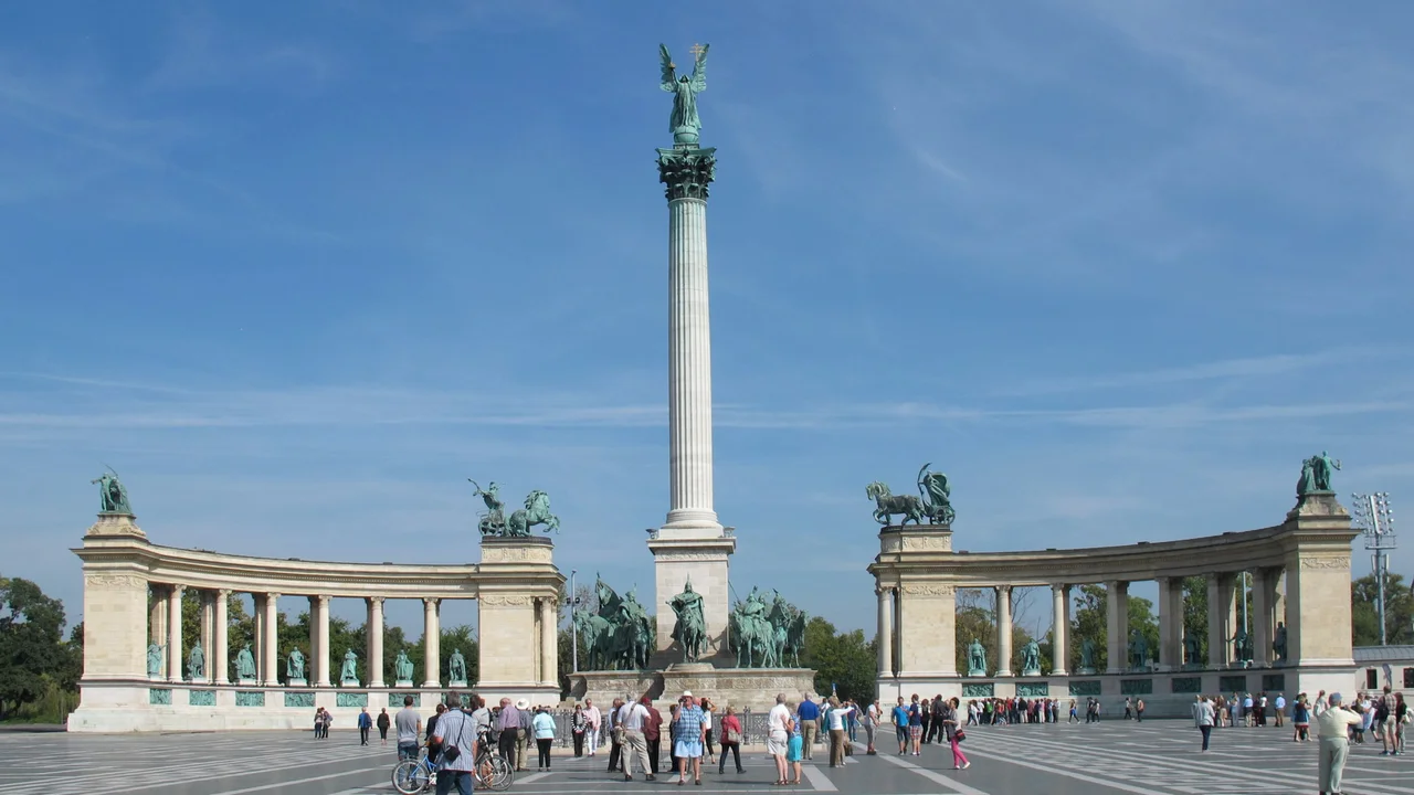 Heroes’ Square (Hősök Tere) in Budapest, Hungary, featuring the Millennium Monument with statues of Hungarian leaders and visitors gathered in the historic plaza near City Park.