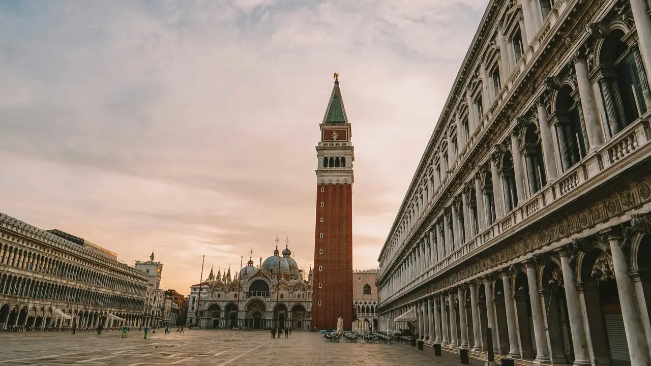 St. Mark’s Square (Piazza San Marco) in Venice, Italy, featuring St. Mark’s Basilica, the Campanile bell tower, and historic arcaded buildings at sunset.