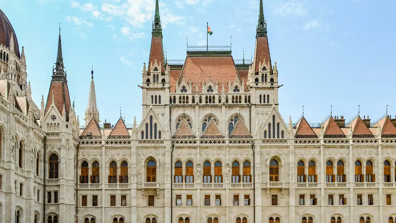 Visit the Hungarian Parliament Building in Budapest, showcasing its grand Gothic Revival architecture, ornate spires, and iconic facade along the Danube.