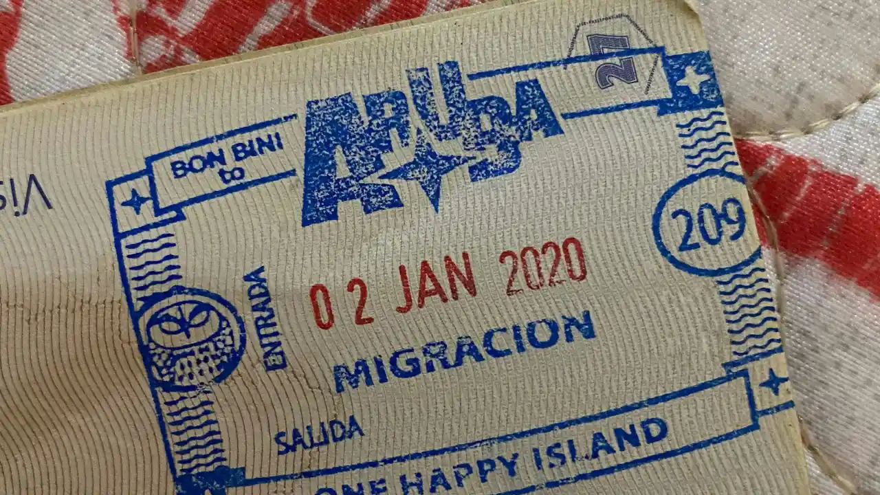 Close-up of passport immigration stamp from Aruba dated 02 Jan 2020 with entry and exit markings for One Happy Island travel destination