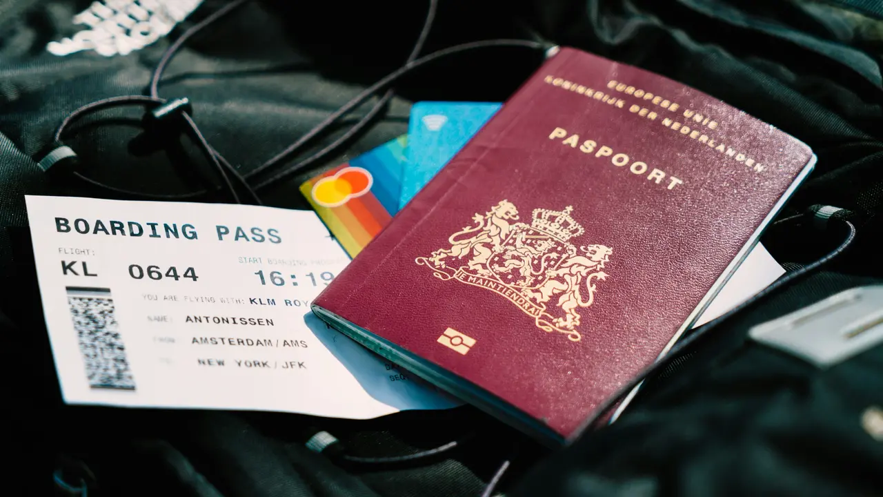 Passport with boarding pass and credit cards placed in a travel bag, representing international travel documents, visa requirements, and flight preparation for overseas trips.