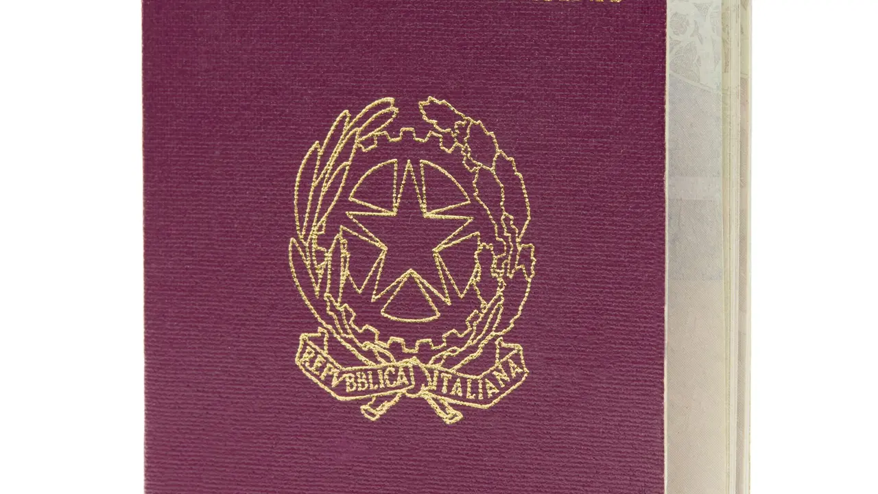 Italian passport cover with gold Republic of Italy emblem (Repubblica Italiana) on burgundy background, official biometric travel document.