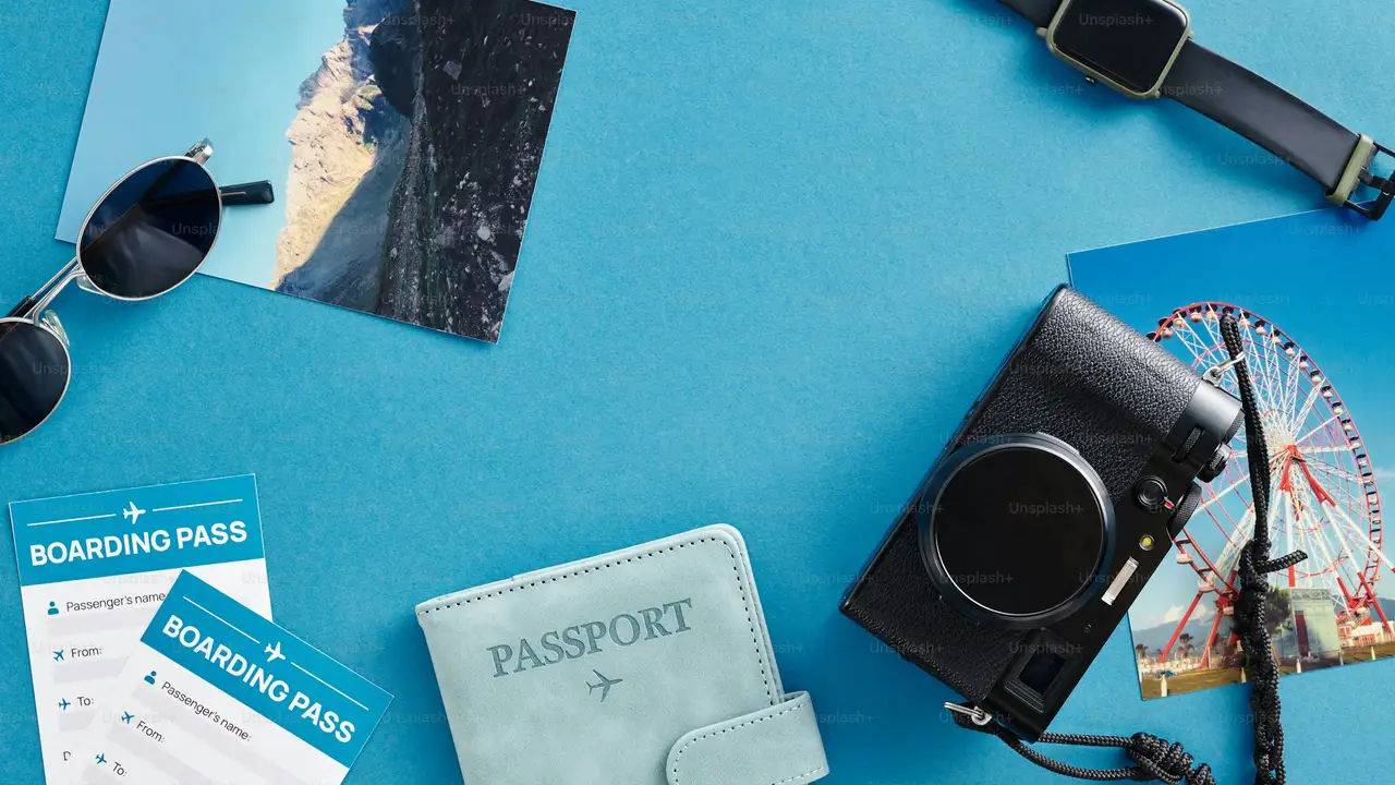 Valid passport with boarding passes, camera, and travel accessories on blue background, representing passport validity requirements for international travel and visa applications.