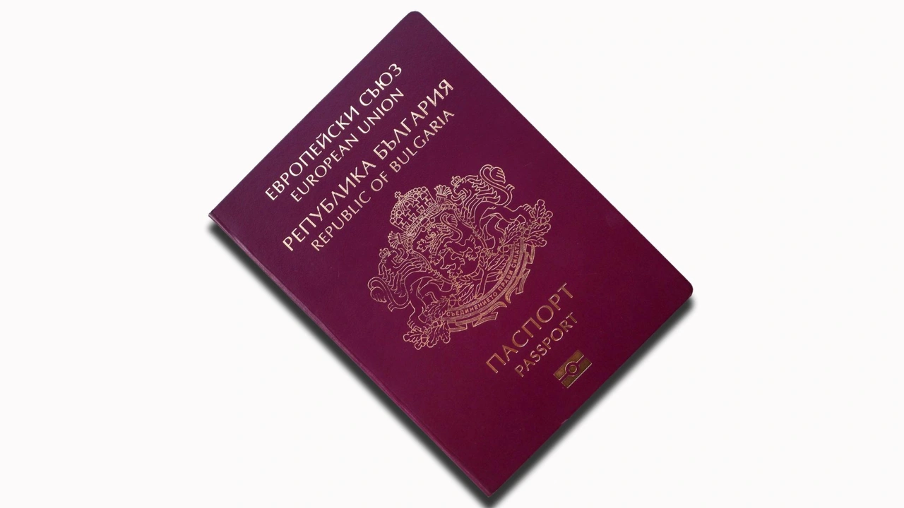 Close-up of a burgundy European Union passport from the Republic of Bulgaria with gold embossed coat of arms and bilingual text on the cover, isolated on a white background.