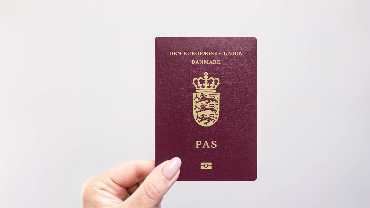 Hand holding Danish European Union passport isolated on white background, Denmark biometric passport for international travel and EU citizenship