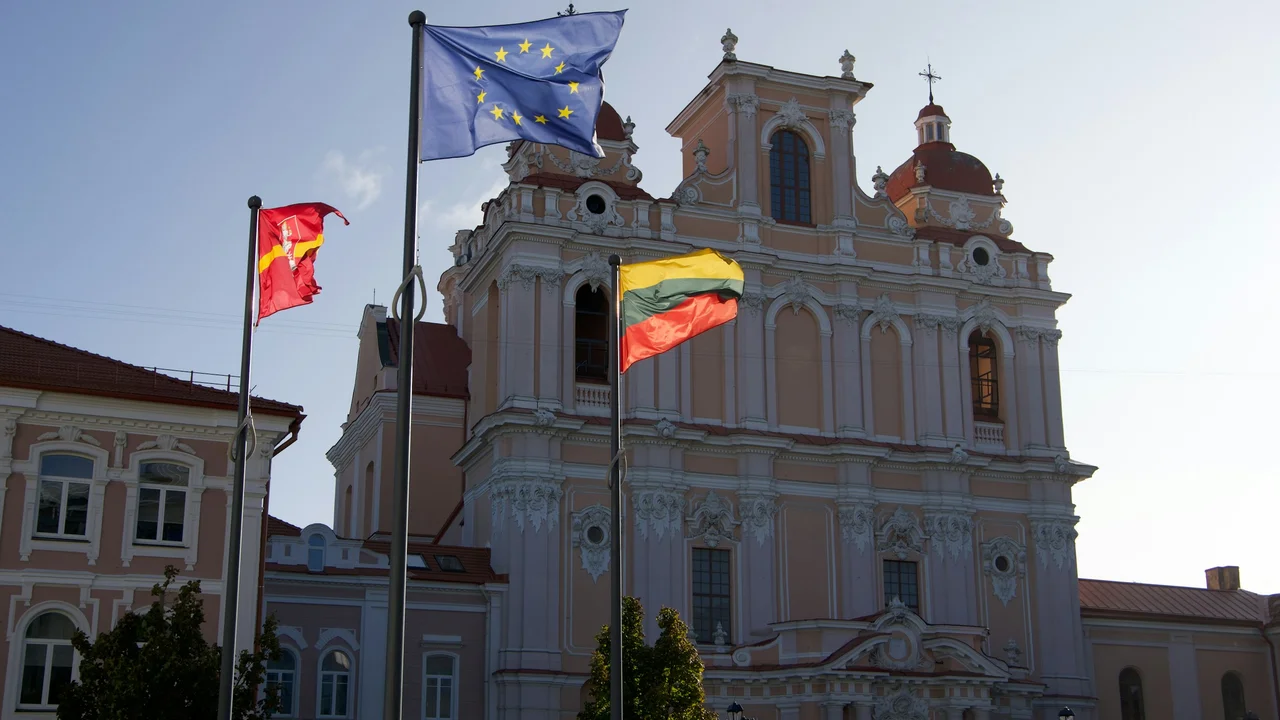 European Union, Lithuania and Vilnius city flags waving in front of St. Casimir’s Church baroque facade in Vilnius Lithuania