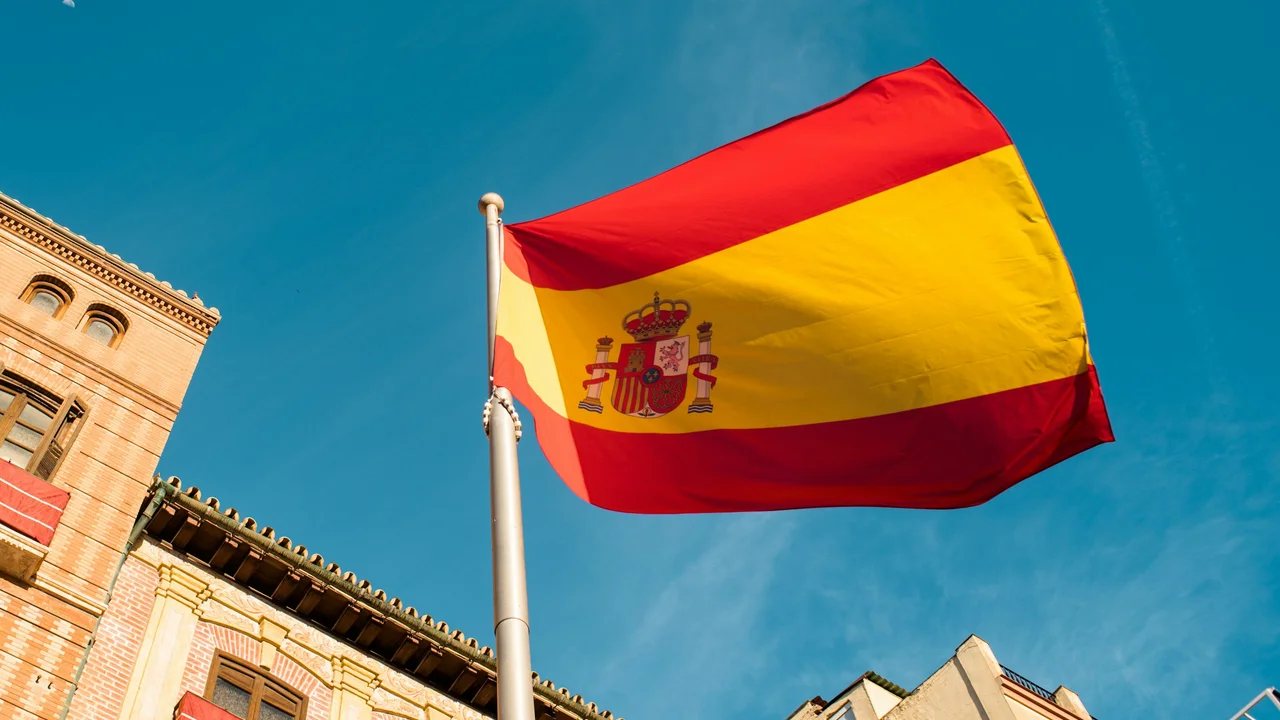 spain flag front of spain building