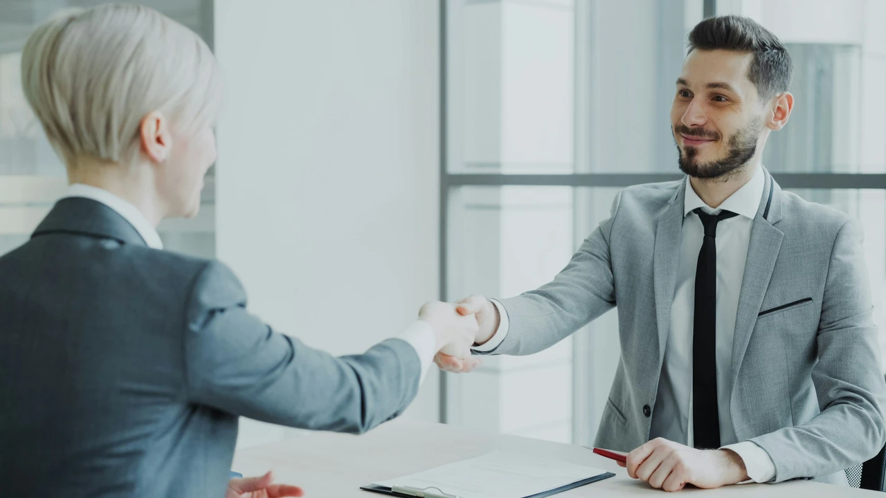 Professional job interview handshake between employer and candidate in modern office setting symbolizing successful hiring and career opportunity