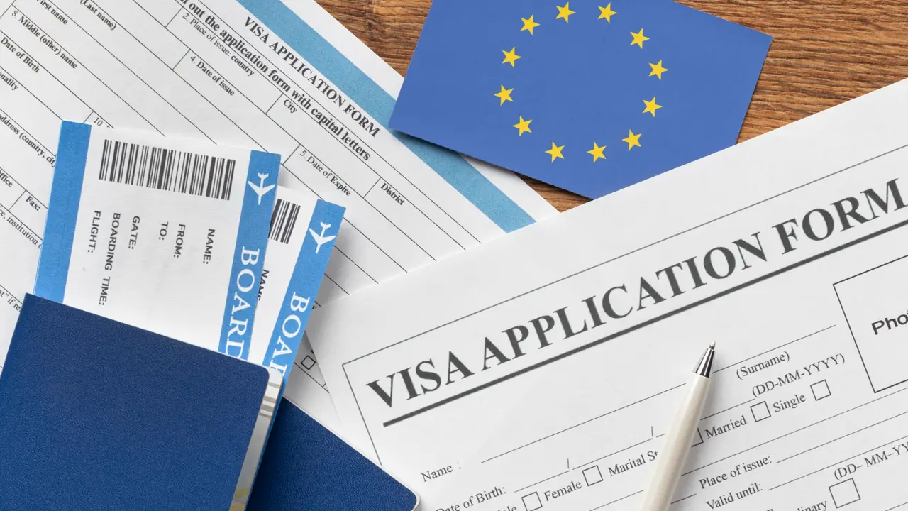 EU visa application form with passport, boarding passes, and European Union flag on wooden desk representing travel and immigration process