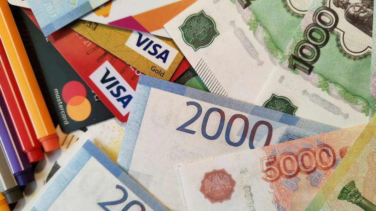 An overhead, close-up shot of a messy pile featuring Russian Ruble banknotes and credit cards