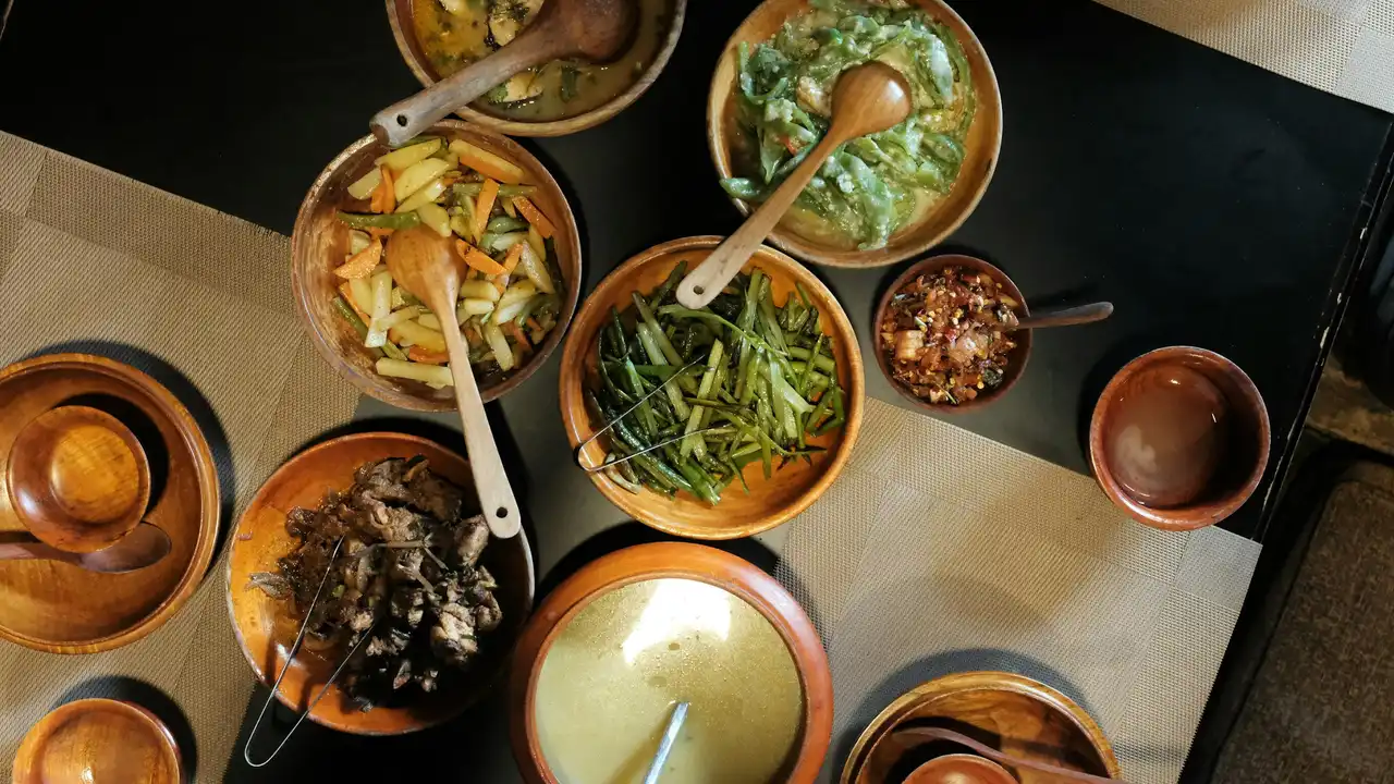 Traditional Bhutanese food served in wooden bowls, featuring local vegetables, curries, and authentic Bhutan cuisine prepared for travelers and tourists