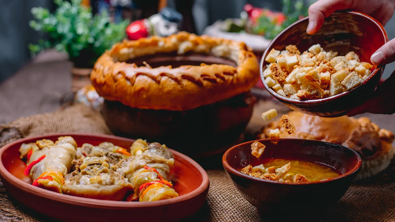 Traditional Eastern European Christmas Eve meal featuring kutia topped with bread cubes, stuffed cabbage rolls, and festive braided bread on a rustic holiday table setting