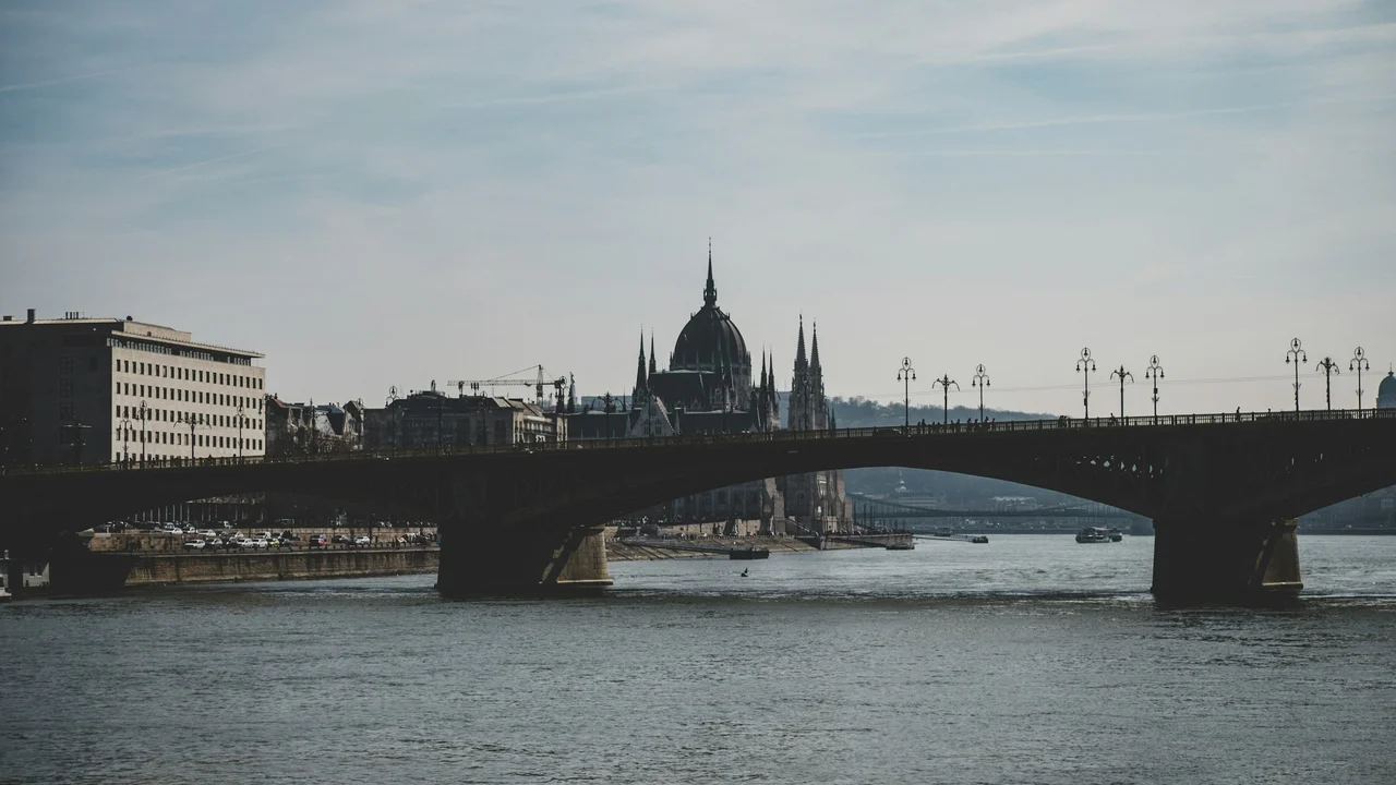 View of the Danube River and Margaret Bridge with the Hungarian Parliament Building in Budapest, Hungary, showcasing historic architecture and city skyline.