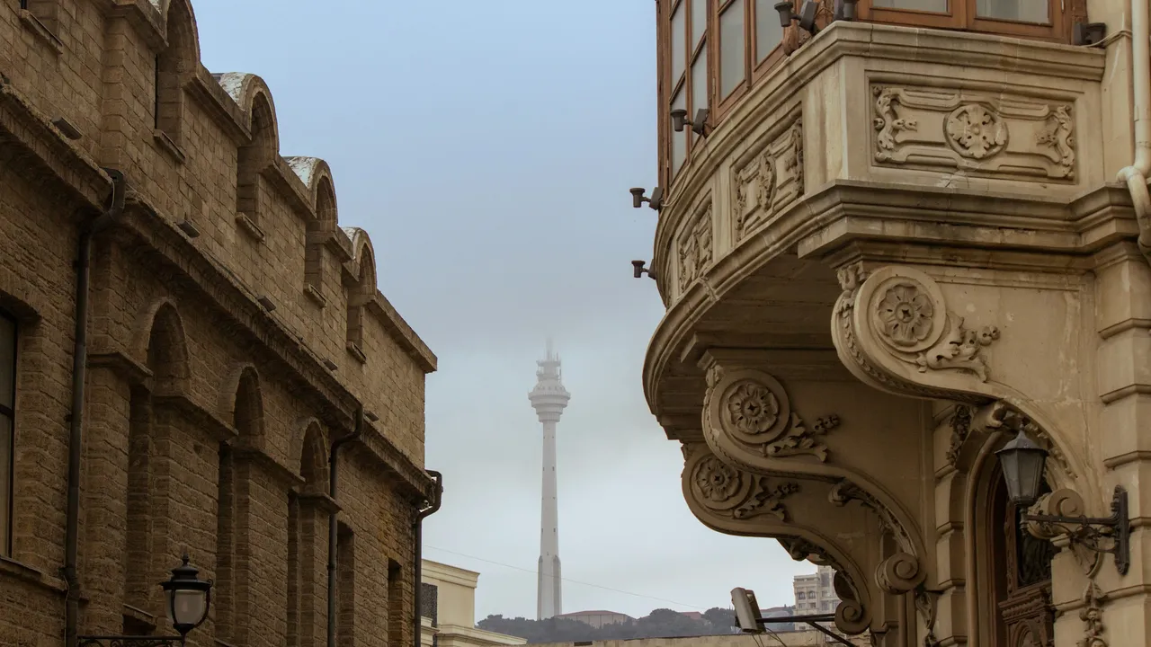 Historic architecture in Baku Old City with ornate stone buildings and Baku TV Tower in the background Azerbaijan