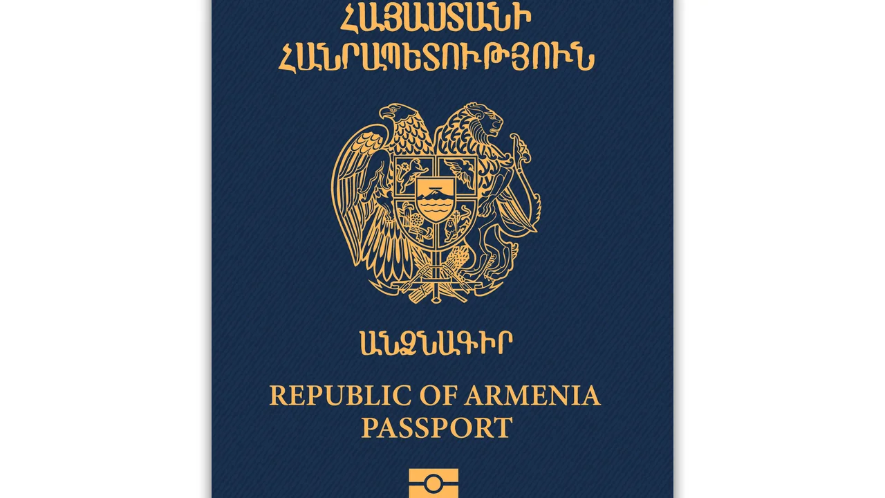 Close-up of a Republic of Armenia passport cover featuring the Armenian coat of arms in gold on a dark blue background with Armenian script and the text “Republic of Armenia Passport” in English.
