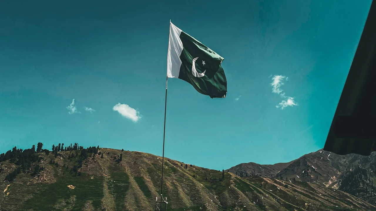 Requirements for Pakistani nationals for visa-free entry – Pakistani flag waving against a mountainous landscape, symbolizing visa-free travel eligibility and entry conditions for Pakistani passport holders.