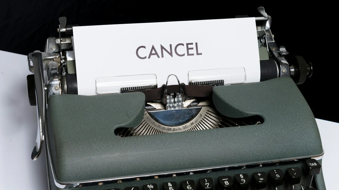 A close-up photograph of a vintage, olive-green typewriter with a white piece of paper inserted into the roller. Centered on the paper is the word