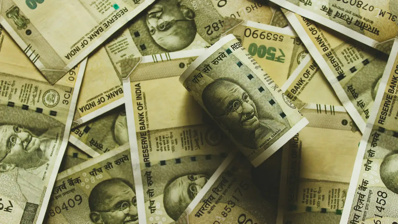 Scattered Indian ₹500 currency notes featuring Mahatma Gandhi, representing Indian money, finance, and economic costs.