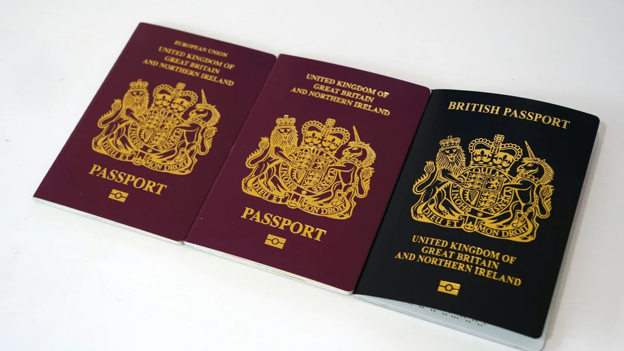 Three United Kingdom passports displayed side by side, showing two burgundy EU-era UK passports and one black post-Brexit British passport on a white background.