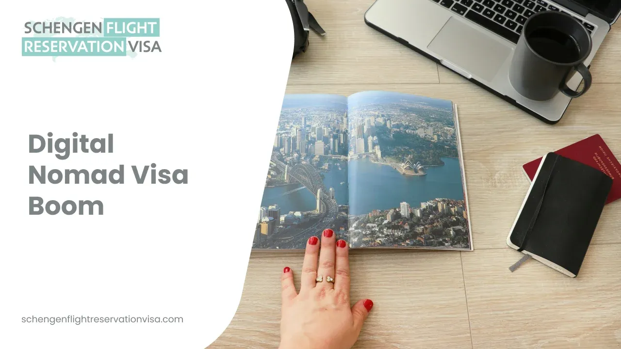 The image shows a top-down view of a wooden desk with a laptop, a black coffee mug, a black notebook next to a red passport, and a hand with red nail polish holding open a travel book featuring a scenic aerial view of a coastal city.